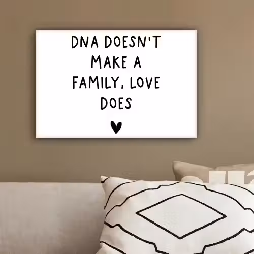 Engelse quote "DNA doesn't make a family, love does" met een hartje op een witte achtergrond canvas 2cm klein -sfeer3