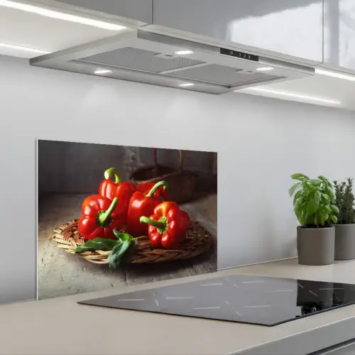 Vier rode paprika's op een rieten mand keuken achterwand spatscherm klein -3d_schuin